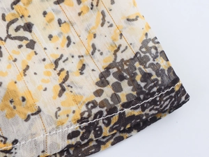 Detail of leopard print chiffon fabric featuring precise double-stitch sewing craftsmanship