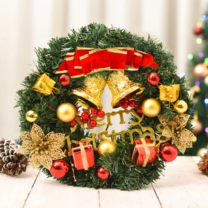 Christmas pine needle wreath with golden bells, red ornaments, and Merry Christmas sign
