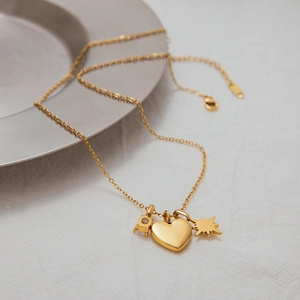 Detailed view of gold stainless steel heart and star charms on a delicate link chain