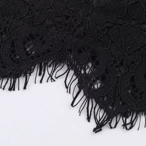 Gros plan sur la dentelle florale noire avec des franges et une texture fine