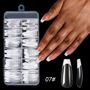 Detail view of long coffin French press-on nails with white tips in storage box