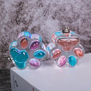 Dettaglio dello stampo in resina a forma di zampa di gatto con glitter colorati all'interno