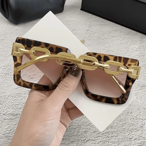 Detalle de montura cuadrada de leopardo con patillas de cadena dorada y lentes degradadas café