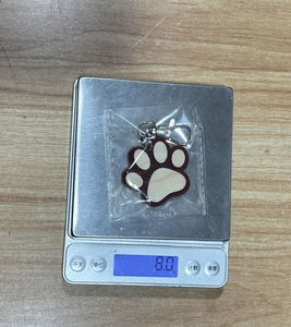 Detailed close-up of a wooden cat paw keychain pendant showing natural grain and metal clasp