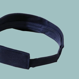 Close-up of the adjustable velcro strap on the back of a navy blue breathable sun visor
