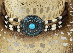 Macro detail of bohemian hat band with turquoise stones and vintage silver metal medallion