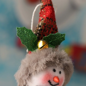 Dettaglio del pupazzo di neve in peluche con cappello scozzese e campanellino d'oro