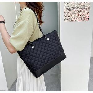 Vue détaillée du grand sac cabas en nylon matelassé noir avec bandoulière en chaîne