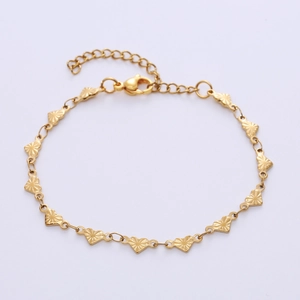 Detail of golden heart-shaped chain bracelet with sunburst texture and lobster clasp