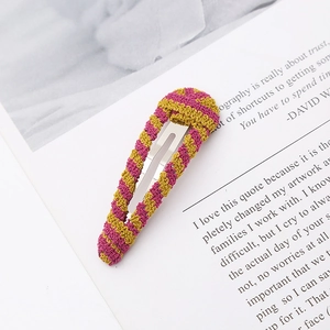 Detail of pink and yellow handmade crochet stripe hair clip on magazine page