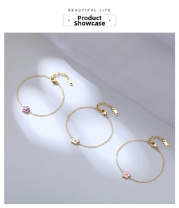 Detailed view of three dainty gold flower bracelets in purple, white, and pink gemstones