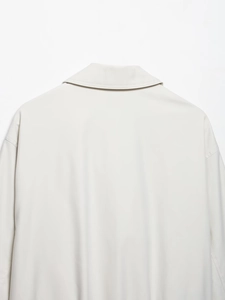 Detail van reverskraag en schoudernaad op lichtgrijze casual jas voor dames
