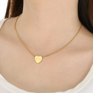Gros plan du collier avec pendentif cœur plaqué or 18 carats et gravure 11:11 sur un mannequin