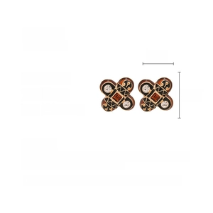 Details von Vintage-Ohrringen mit Emaille-Finish und orangefarbenem Edelstein