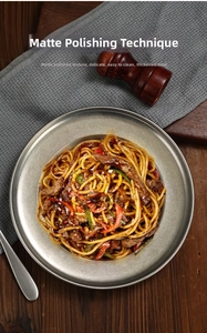 Close-up of thick stainless steel pasta plate with matte brushed finish and beef noodles