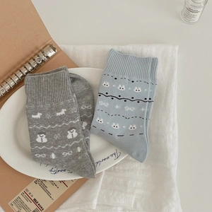 Artistic layout of vintage Fair Isle knit socks with snowman and rabbit patterns