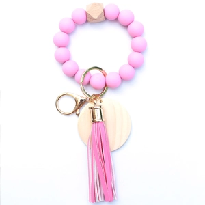 Detail of pink silicone beads, natural wood hex bead, and leather tassel on a key ring