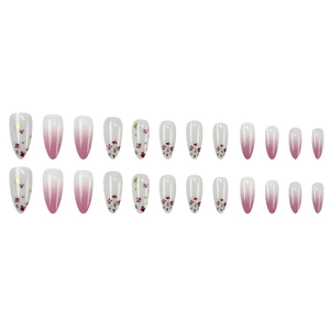 Ombre pink and white press-on nails with floral patterns and gold foil flakes