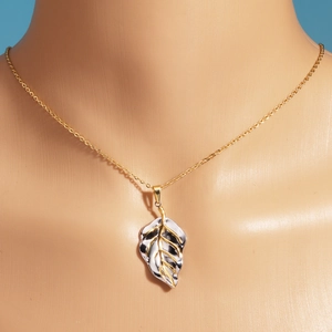 Close-up of gold leaf pendant necklace featuring mixed-metal gold and silver vein textures