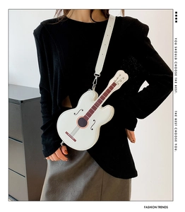 Close-up of white guitar-shaped crossbody bag showing detailed strings and silver hardware