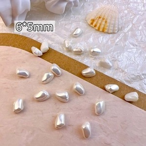 Detail of 6x5mm Baroque irregular pearl nail art charms on a soft pink background