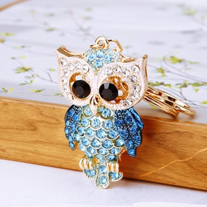 Sparkling rhinestone owl keychain with blue and white crystals on a gold metal base