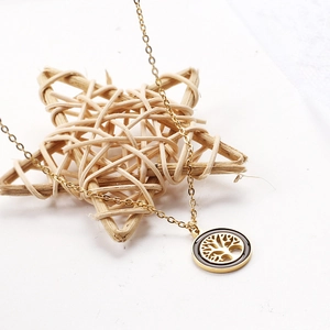 Close-up of a 18k gold-plated Tree of Life necklace set on white background with star decor