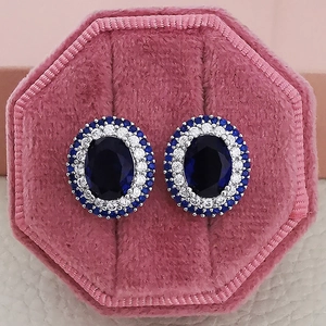Close-up of sapphire blue heart butterfly stud earrings in a pink velvet jewelry box