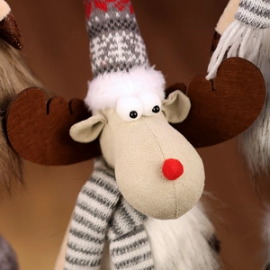 Close-up of plush Christmas reindeer with red nose, knit hat and striped scarf detail