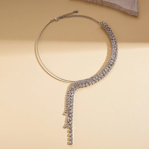 Detail of silver tasseled choker featuring sparkling rhinestones on stone background