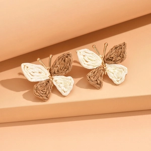 Handmade raffia butterfly earrings in brown and white weave with golden metallic frames