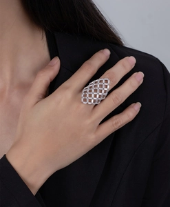 Close-up of hollow grid silver ring with radiant clear gemstones on model hand