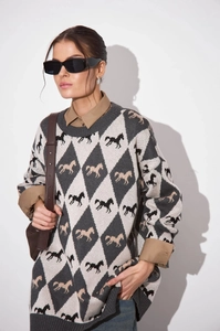 Close-up of knit crewneck sweater featuring argyle patterns and horse motif embroidery