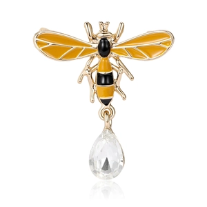 Elegant gold bee brooch featuring yellow enamel wings and a clear crystal teardrop pendant