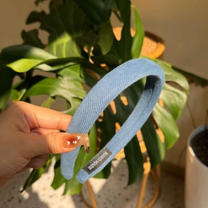 Détail du serre-tête rembourré bleu clair avec étiquette faite main au soleil