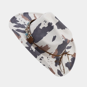 Detailed top view of a white cowboy hat with cow print and ethnic woven band accents