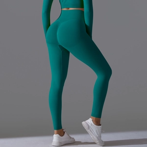 Detail of emerald green seamless yoga leggings with peach butt lifting scrunch design