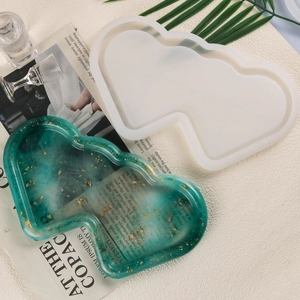 Macro detail of mushroom shaped silicone resin mold and green tray with gold leaf flakes