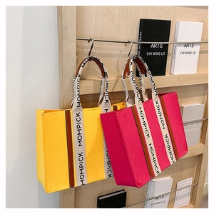 Felt tote bags in yellow and magenta with MOMPICK printed straps on display