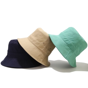 Three cotton bucket hats in navy, beige, and mint green with breathable eyelets for sun protection