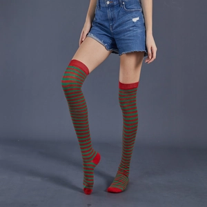 Detail view of red and green striped over-knee socks on a model for Christmas style