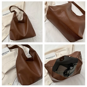 Macro detail of brown leather tote showing stitching, spacious interior and side profile