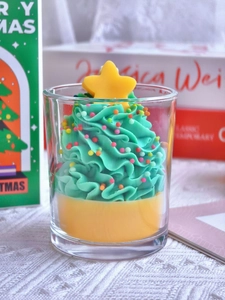 Macro shot of green Christmas tree scented candle with colorful beads in glass