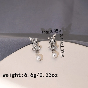 Detail view of silver rabbit earrings with sparkling rhinestones and white pearls
