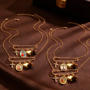 Detail of vintage gold religious necklaces with cross and saint charms on silk