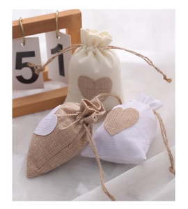 Detail of linen drawstring gift bags with heart pattern for wedding candy packaging