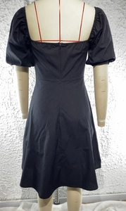Detailed back view of a black puff sleeve dress showing the concealed zipper and waist seam