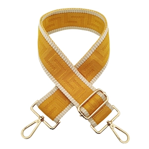 Detail of adjustable 5cm wide woven shoulder strap with gold lobster clasps and maze pattern