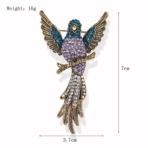 Vintage eagle brooch with colorful rhinestones in blue and purple on a white background