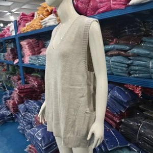 Detailed close-up of beige V-neck knitted sweater vest with ribbed hem and side pocket